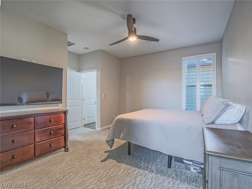 Second bedroom with neutral grey-beige walls and carpet