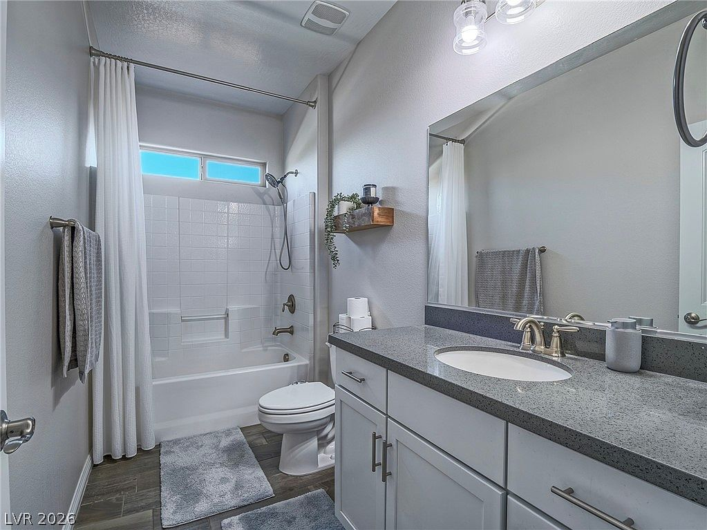 Guest bathroom with grey cabinetry and tub/shower