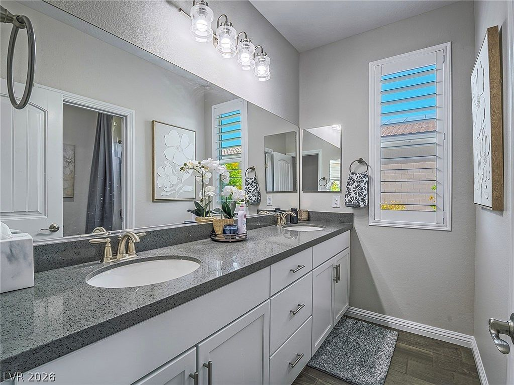 Primary bathroom dual-sink vanity with plantation shutters