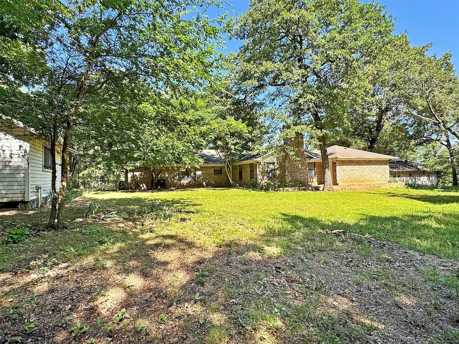 Backyard with mature oak trees and detached outbuilding