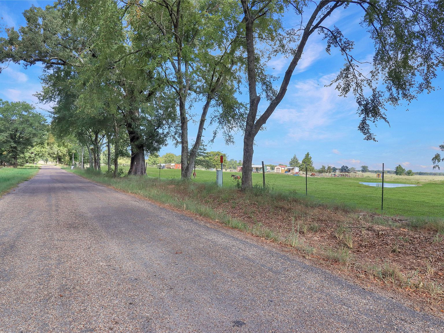 Paved county road frontage with fenced pasture views