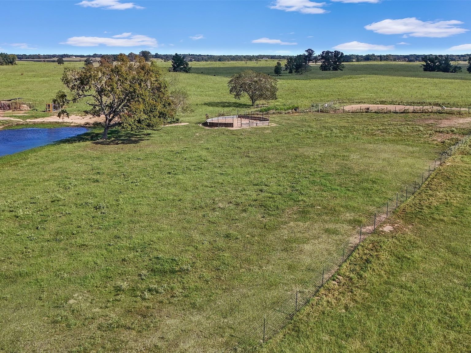 Aerial view of pasture with round pen and pond