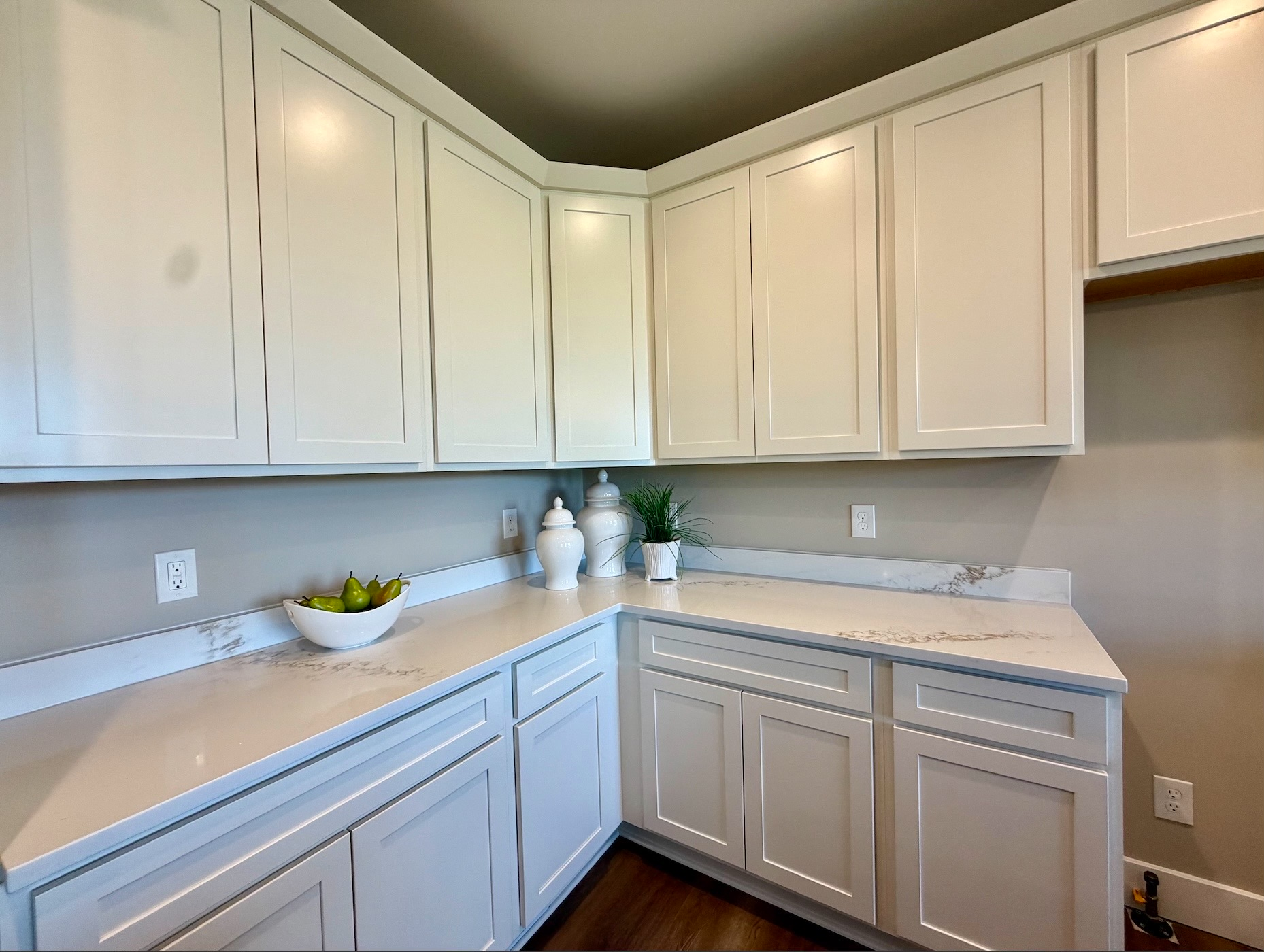 Kitchen quartz countertops with white shaker cabinetry and decorative accents