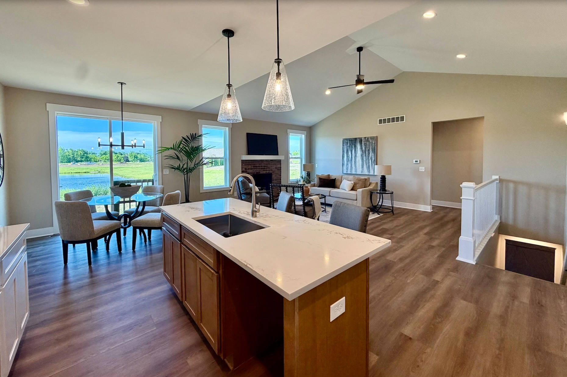 Staged open-concept living room flowing into the kitchen with furnishings