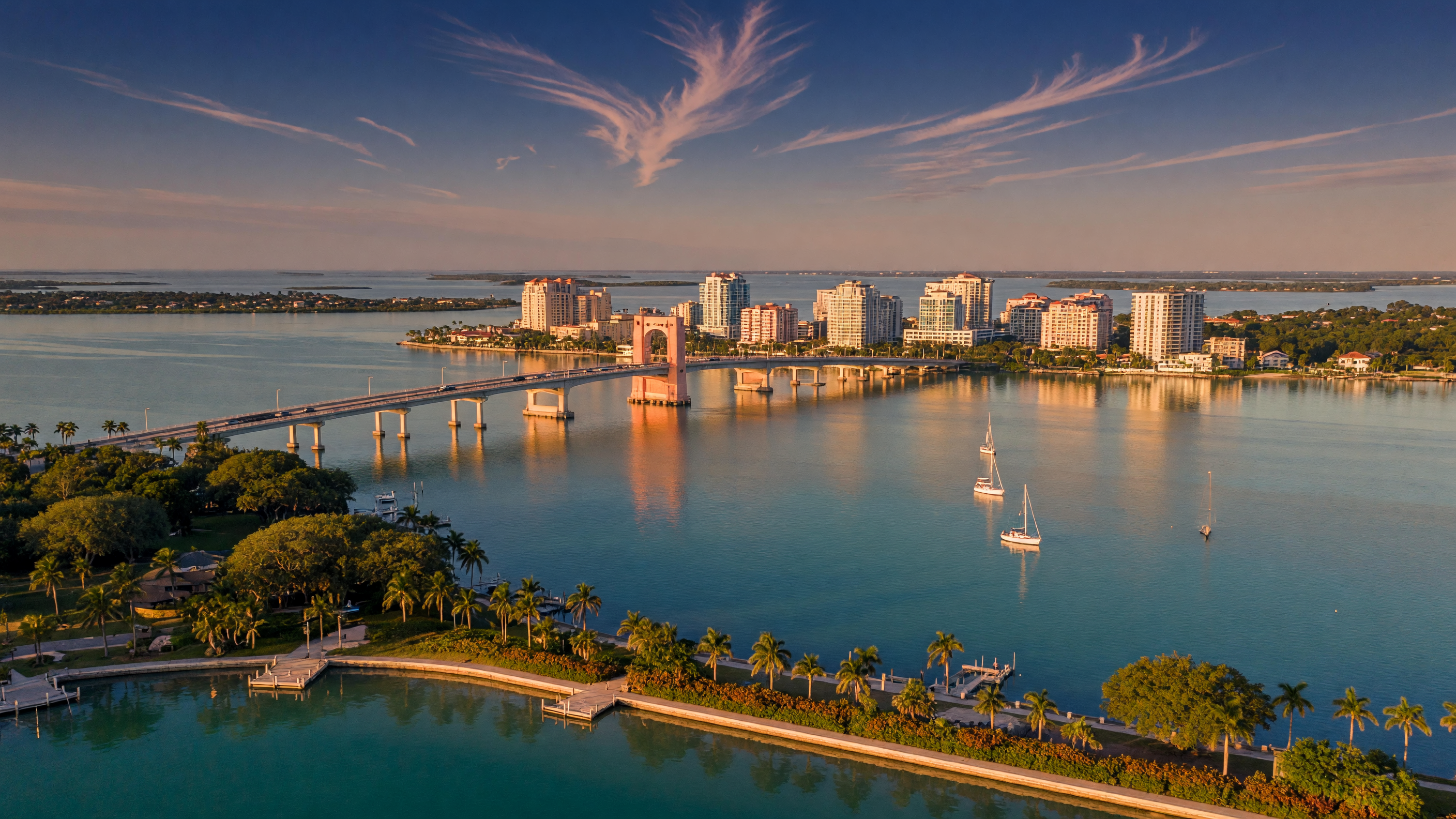 Sarasota Bay waterfront at golden hour with the Ringling Bridge and downtown skyline