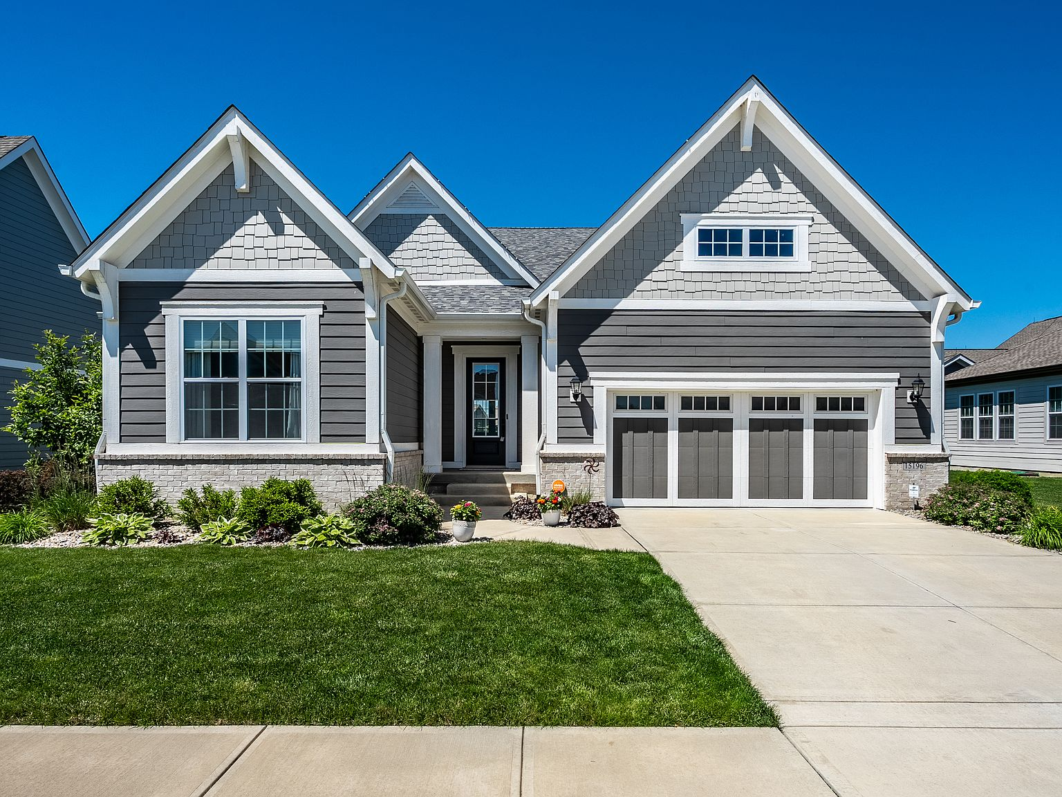 Front exterior of 15196 Larchwood Dr, a Craftsman-style ranch with gray siding and brick accents