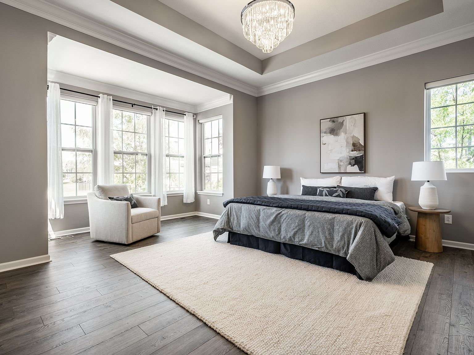 Spacious primary bedroom with multiple windows and natural light