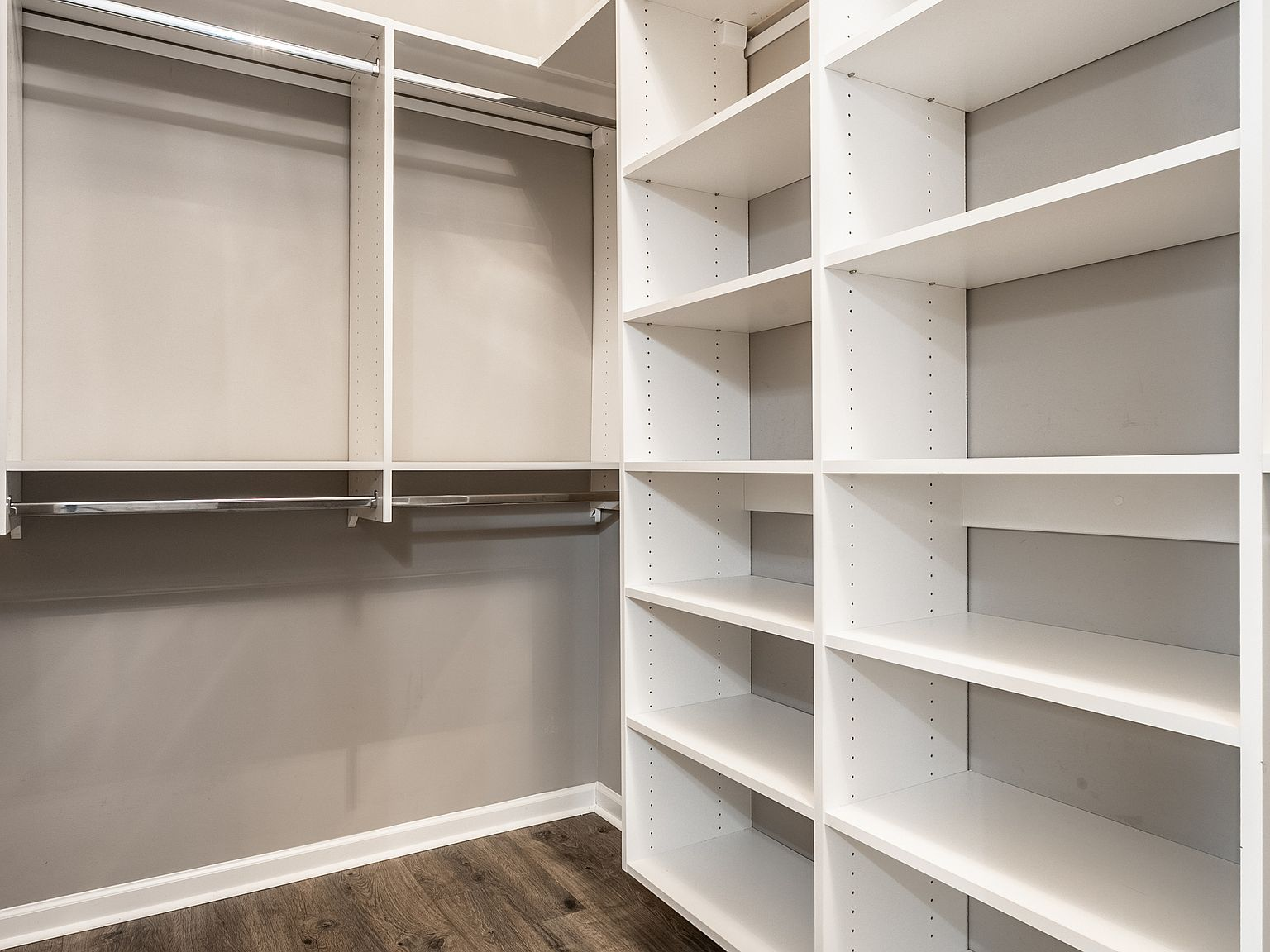 Walk-in closet with white custom built-in shelving and hanging rods