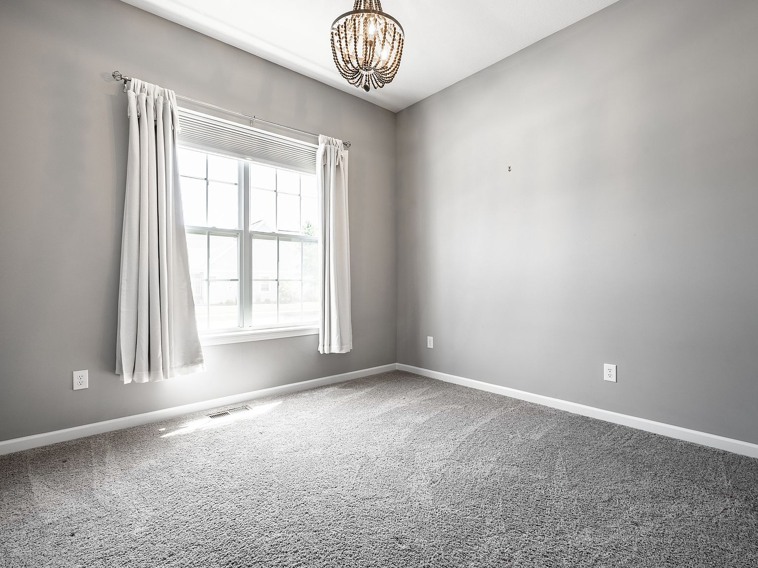 Bedroom with gray walls, beige carpeting, and white trim