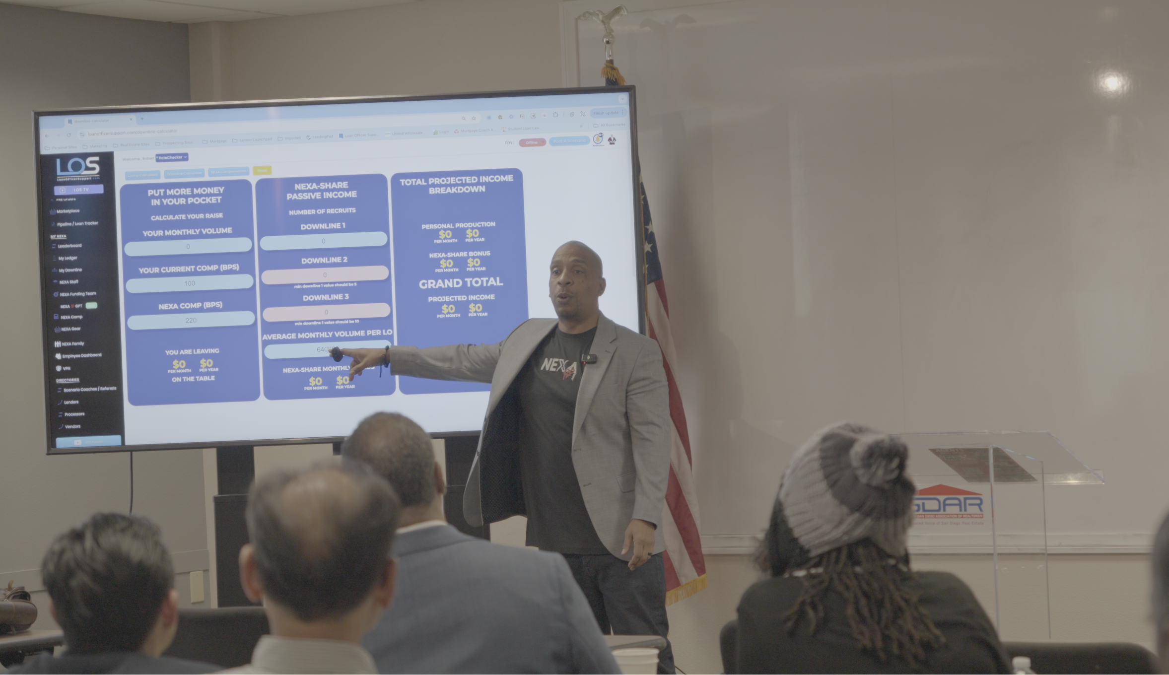 Rob Cole presenting financial diagrams on a large screen at the San Diego Association of REALTORS®