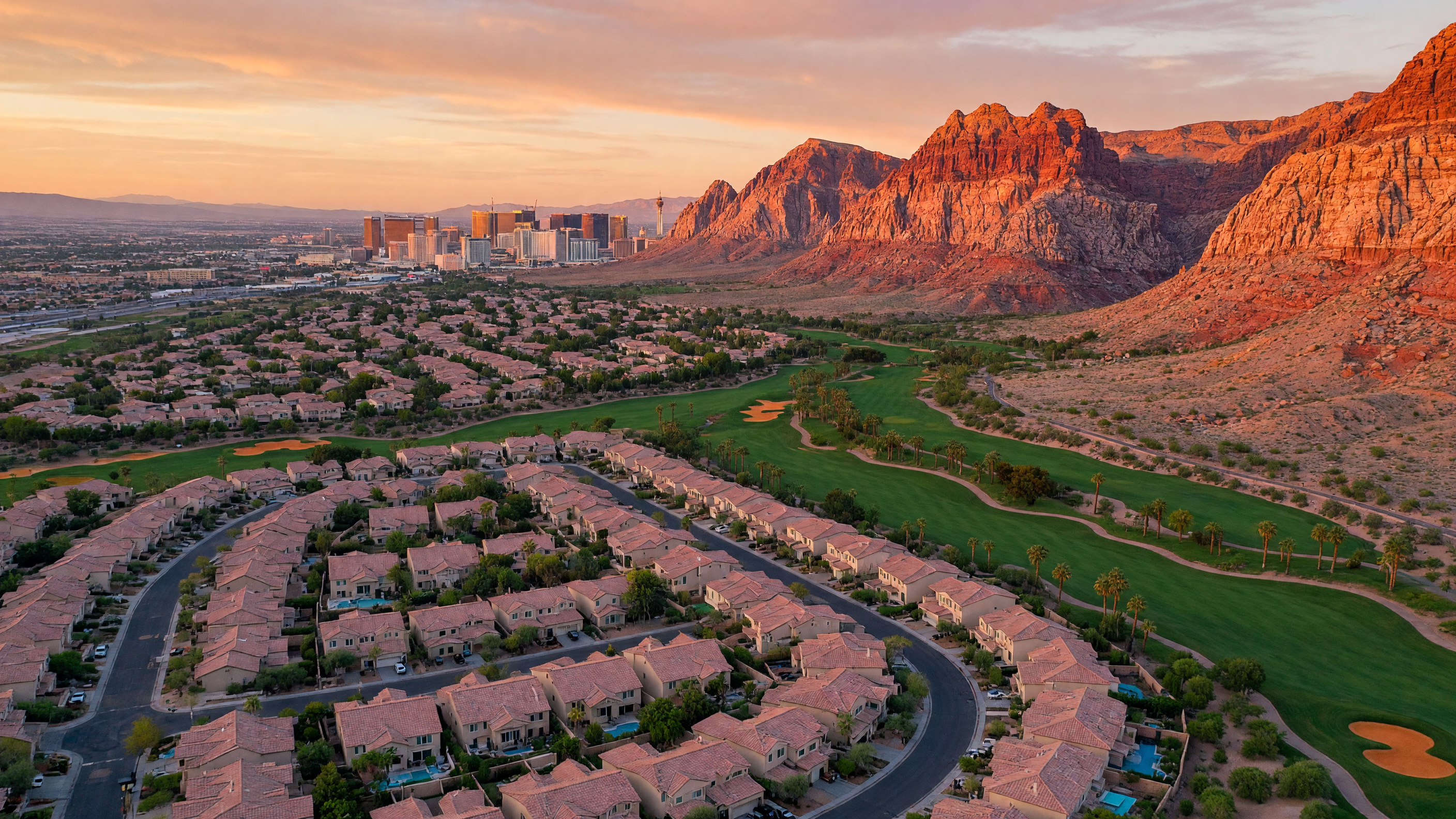 Aerial view of the Summerlin community in Las Vegas with Red Rock Canyon red sandstone cliffs, golf courses, and master-planned neighborhoods at golden hour
