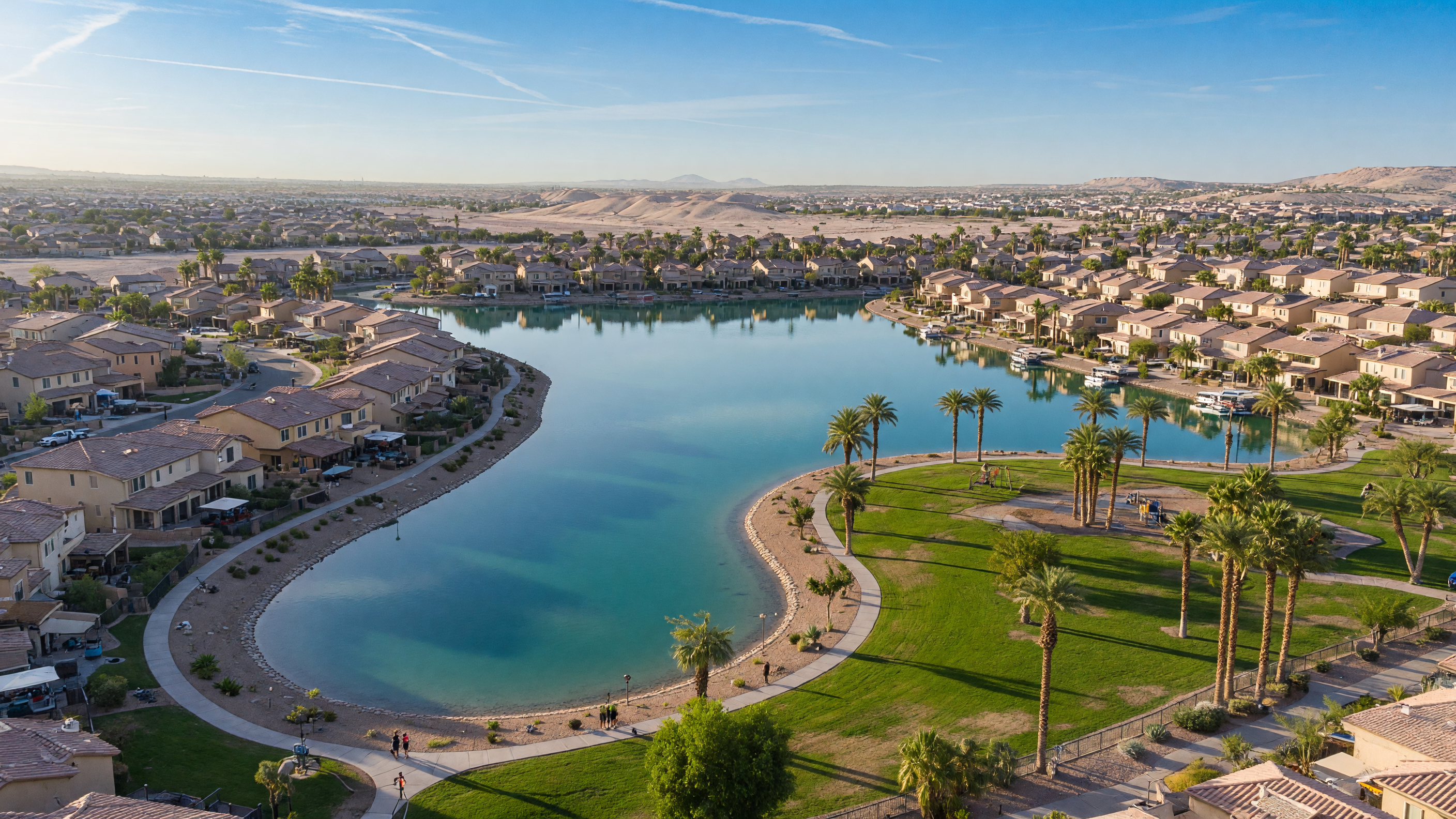 Aerial view of The Lakes waterfront community in Las Vegas with a 30-acre man-made lake, walking paths, and homes along the shoreline