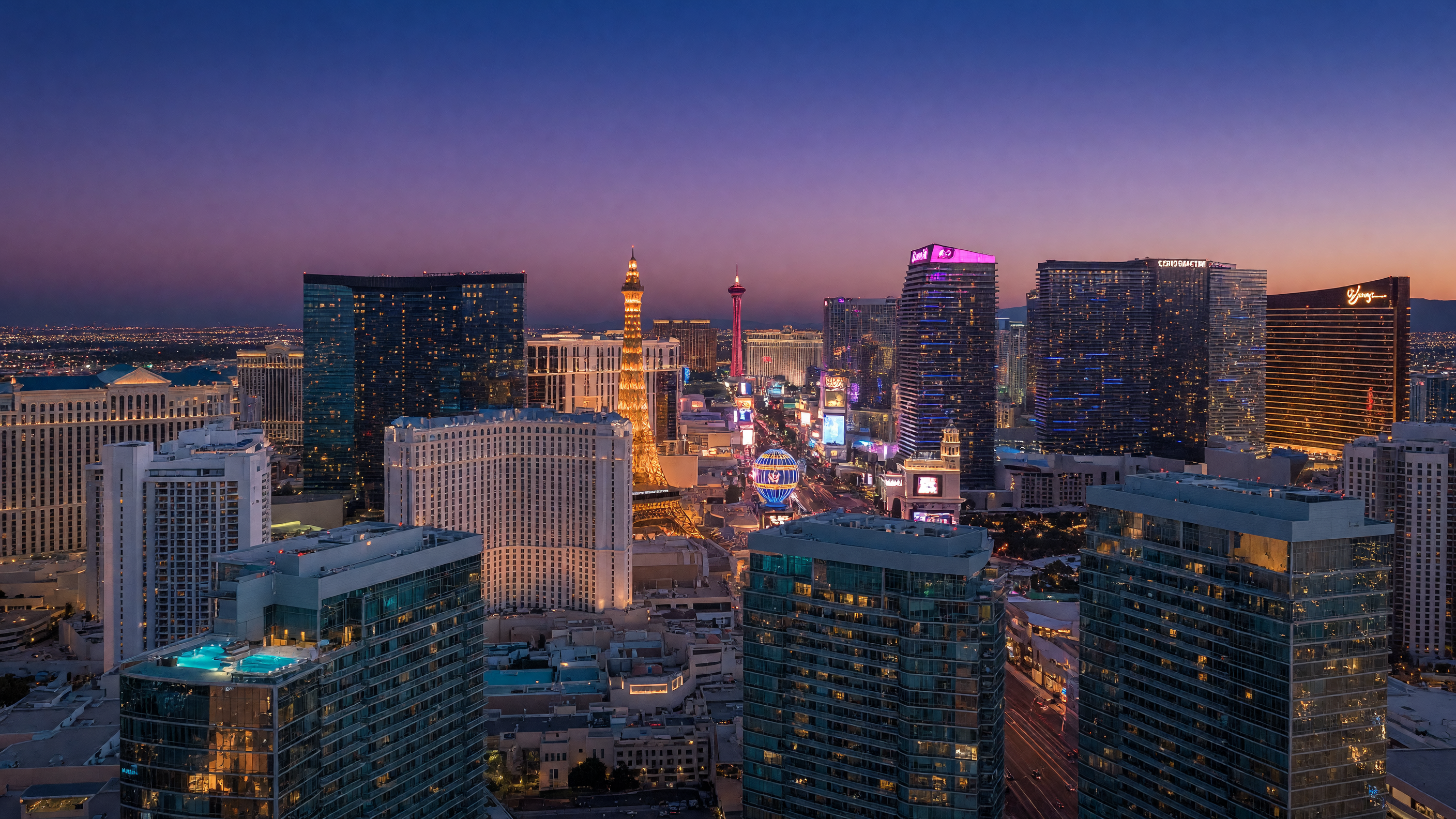 Panoramic view of the Las Vegas Strip skyline at dusk with luxury high-rise condominium buildings illuminated