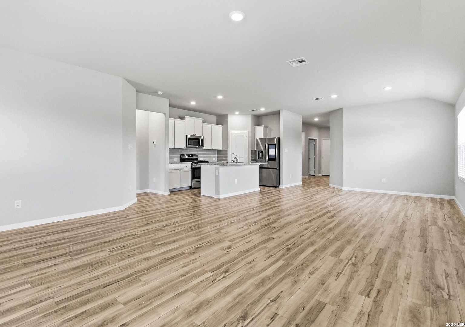 Open-concept living area flowing into the kitchen with granite island