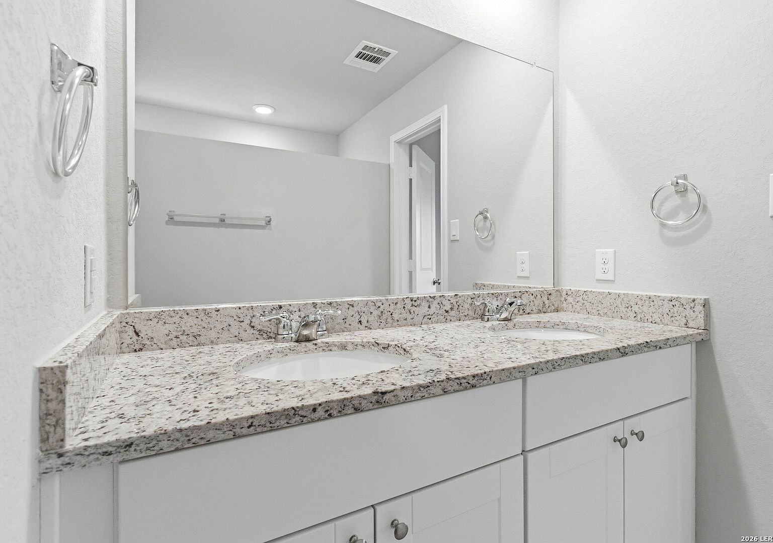 Bathroom with white shaker vanity, granite countertops, and chrome fixtures