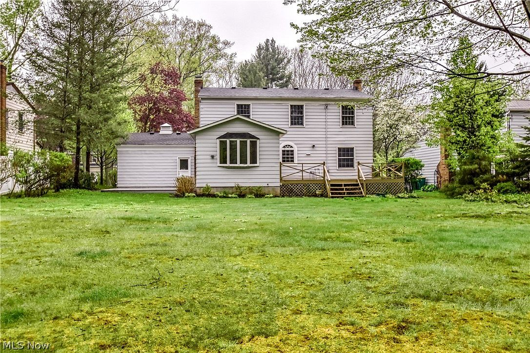 Rear exterior view of home showing bay window and wooden deck