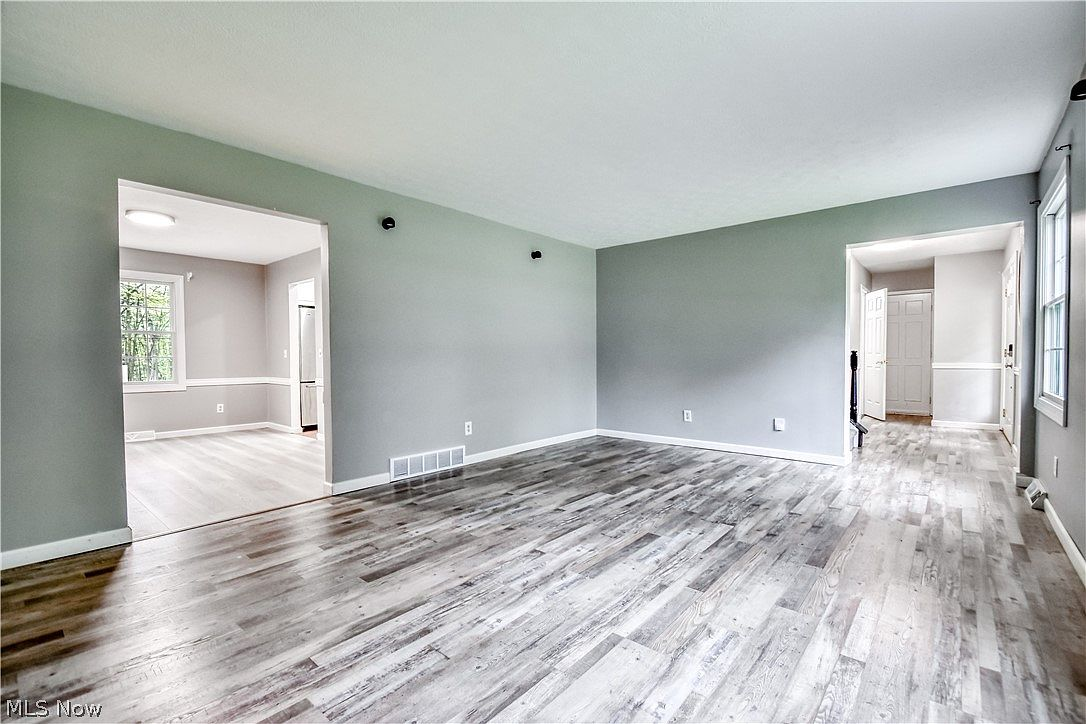 Living room with grey walls, light wood-look flooring, and natural daylight