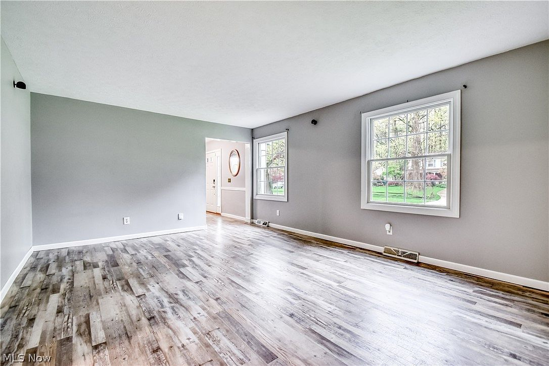 Living room with grey walls, white trim, and wood laminate flooring