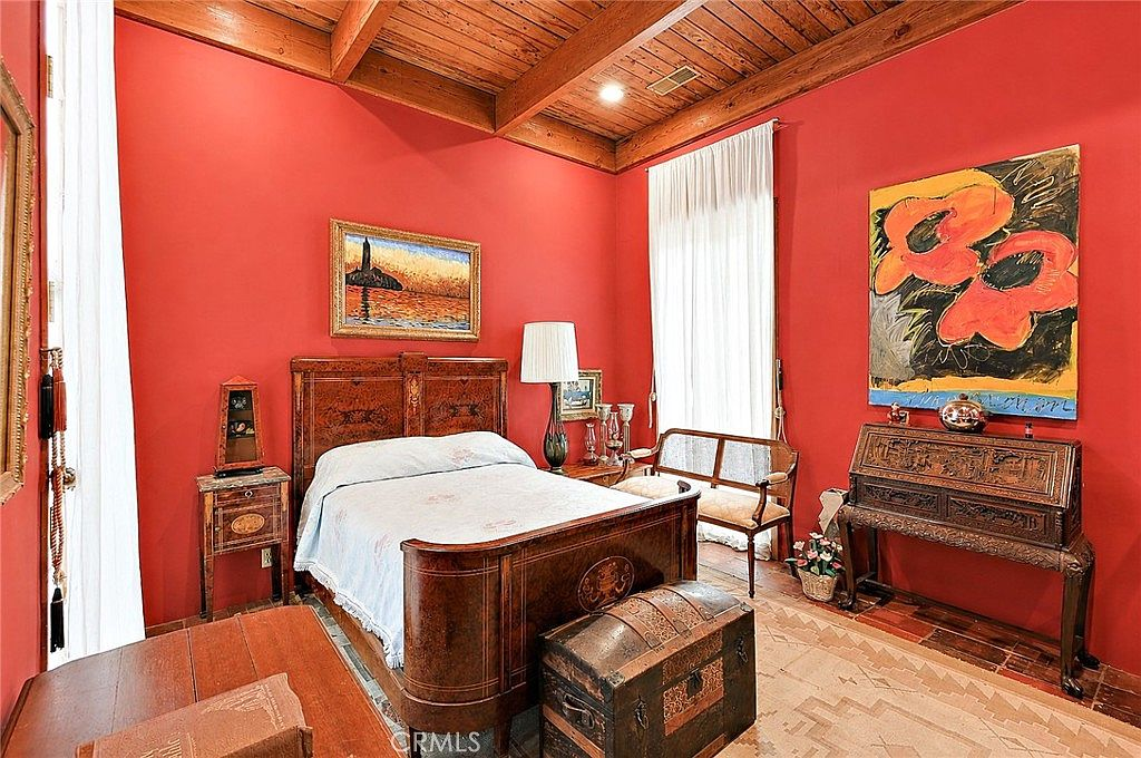 Bedroom with red accent walls and architectural charm