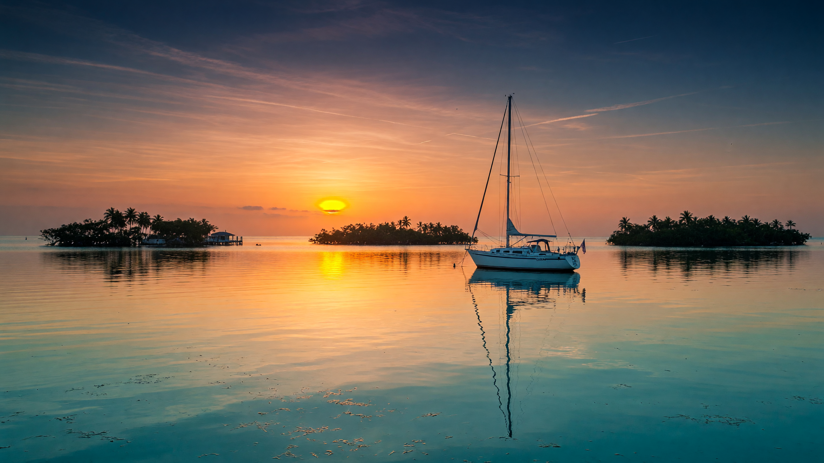 Luxury waterfront estate with private dock and seawall at sunset in the Florida Keys