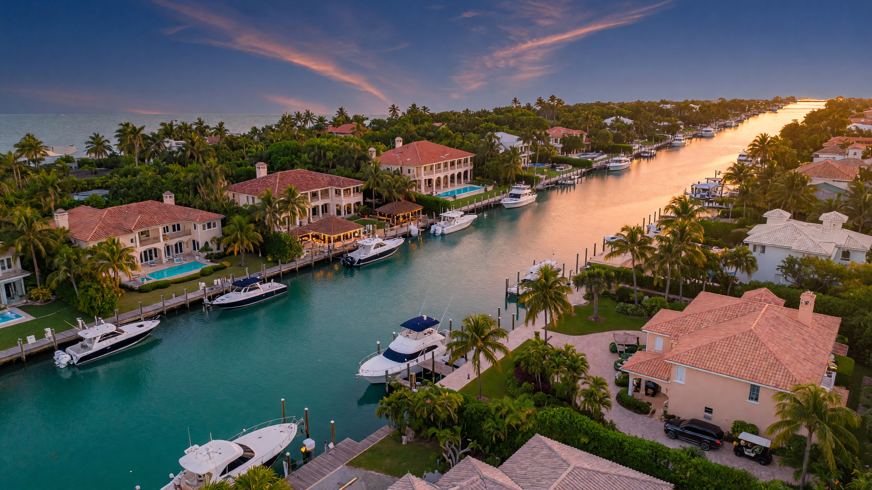 Aerial view of luxury waterfront estates along turquoise canals in the Florida Keys at golden hour