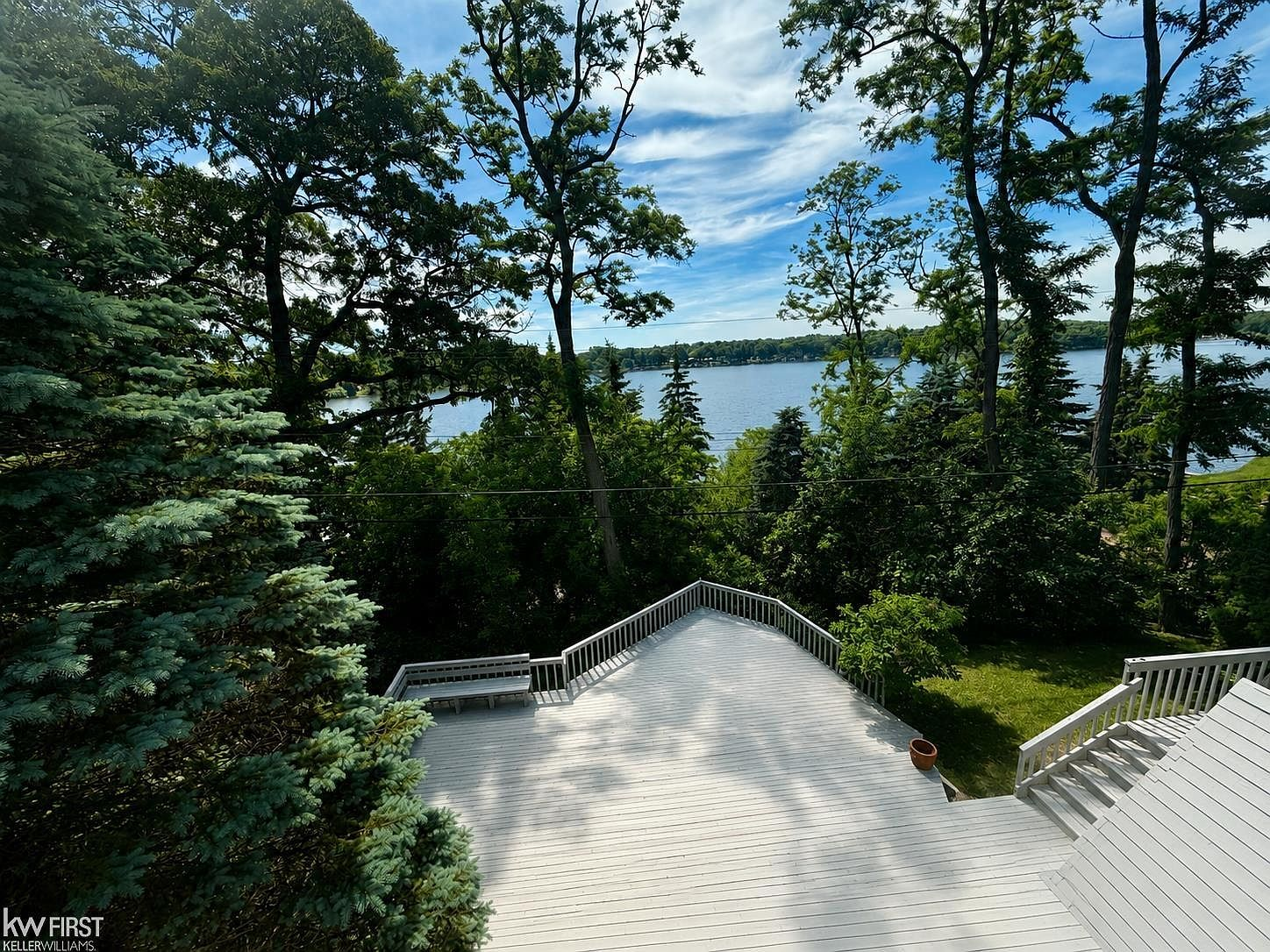 Multi-level deck overlooking Big Lake with built-in bench seating and mature trees