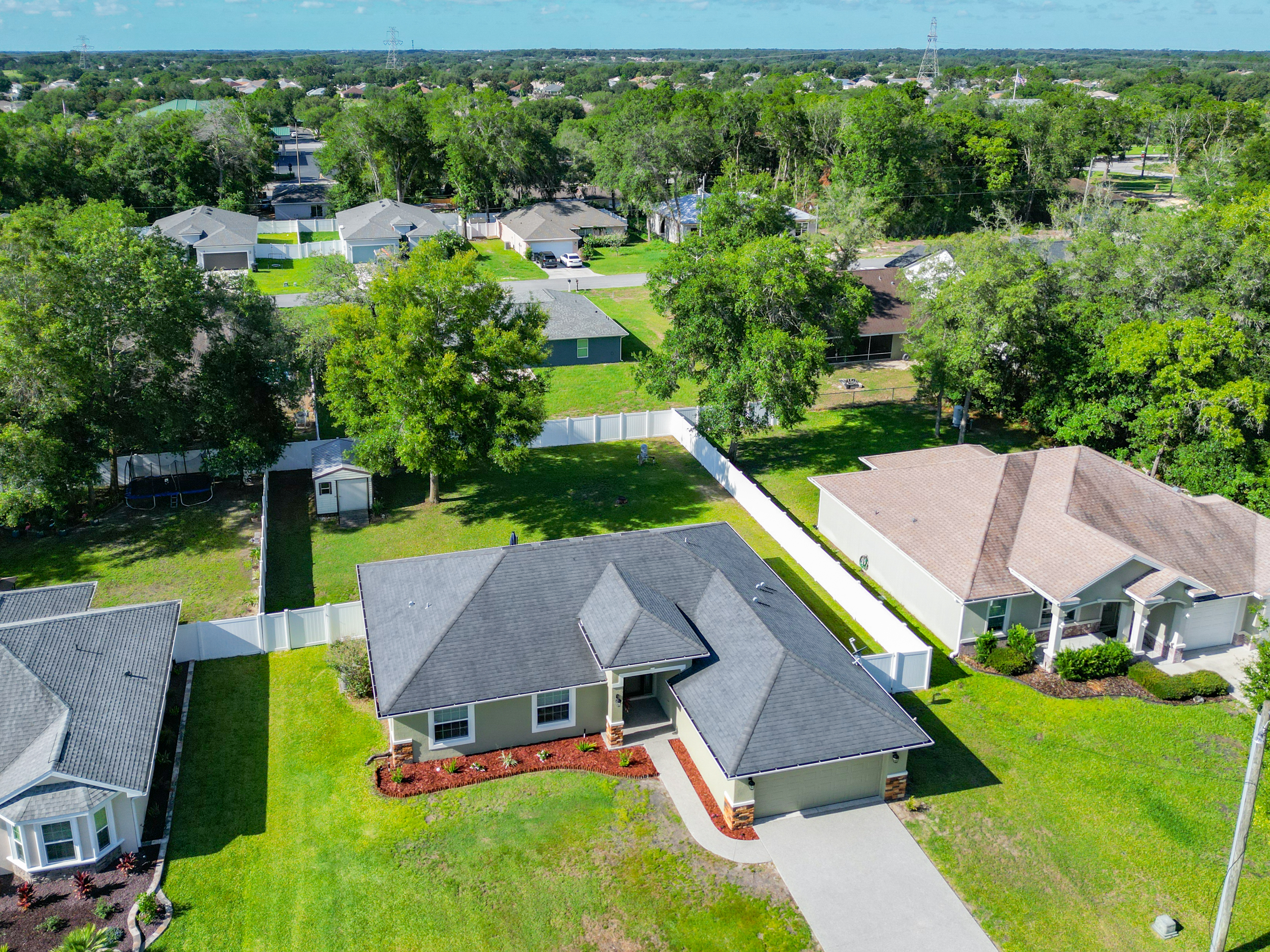 Aerial drone view of the property and surrounding neighborhood