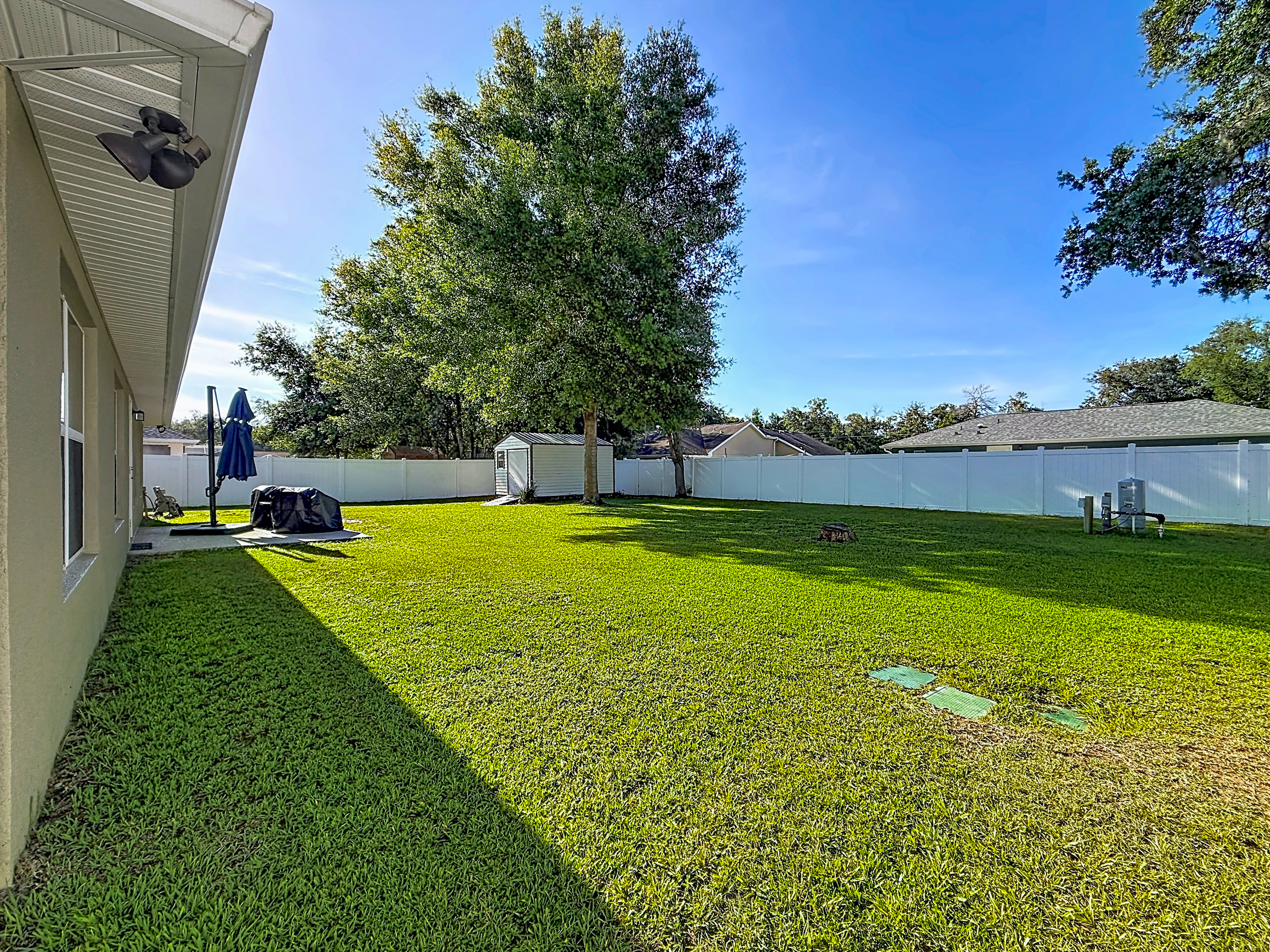 Spacious backyard with white vinyl fencing