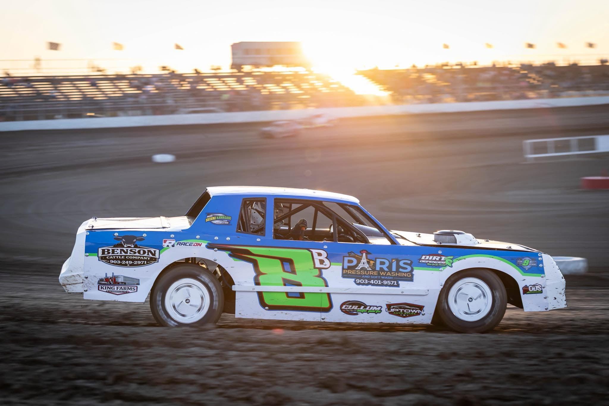 Riley Barnes race car speeding around a dirt track during a golden sunset