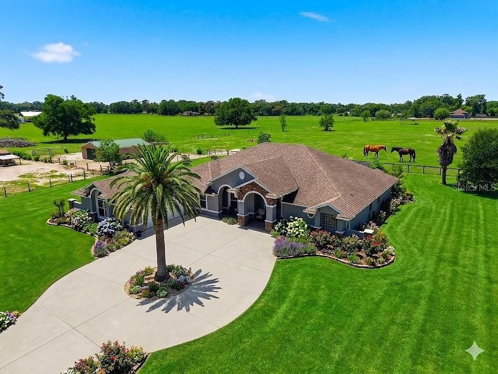 Aerial view of 12764 County Road 223, a ranch-style home on nearly 10 acres with barn and horses