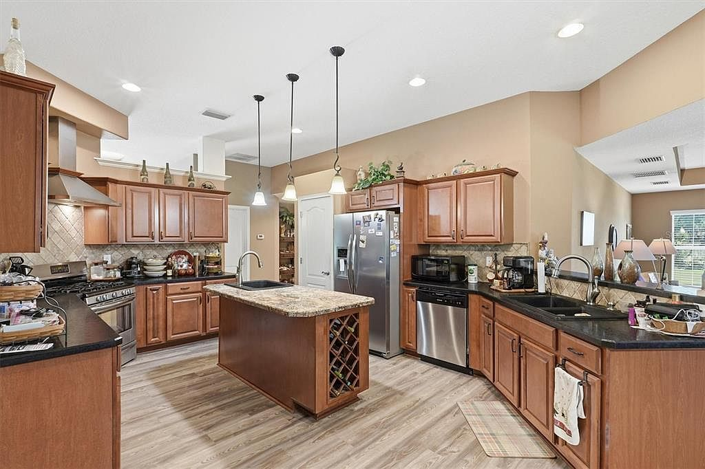 Kitchen with wood cabinetry, granite countertops, and center island