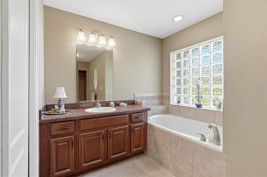 Primary bathroom with soaking tub and glass block window
