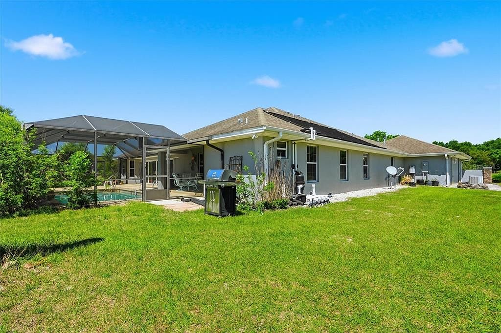 Rear exterior with pool enclosure and backyard