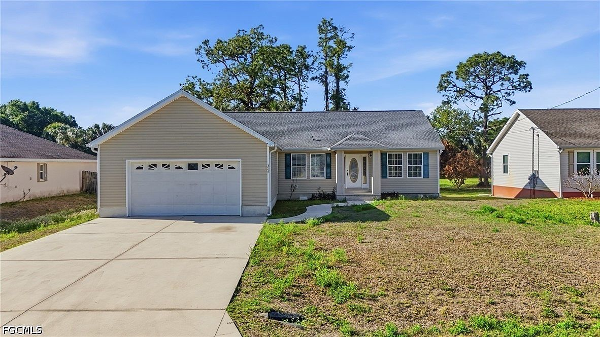 Front exterior of 3005 14th St W, a single-story ranch with beige siding and blue shutters