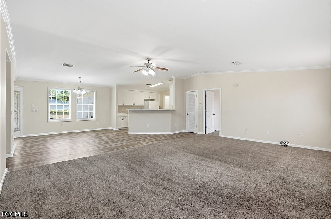 Open-concept living and dining area with carpet and vinyl flooring