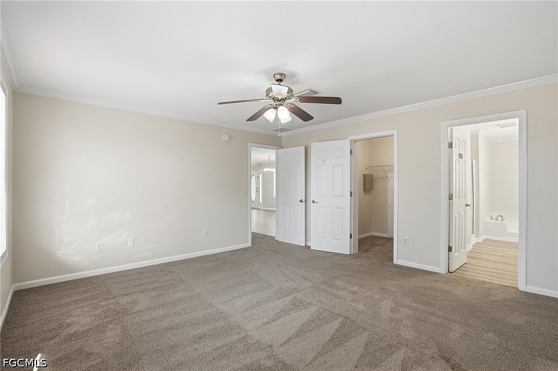 Vacant primary bedroom with grey carpeting and natural daylight