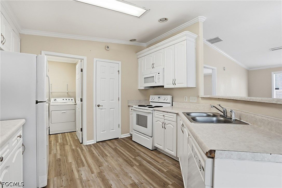 Kitchen with white cabinetry and wood-look vinyl flooring