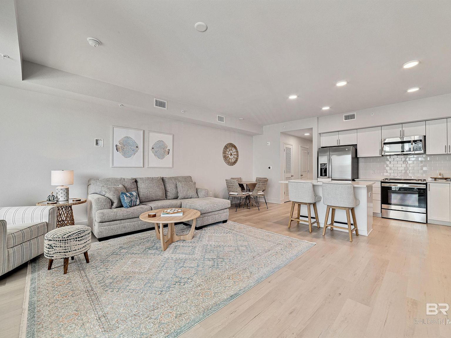 Open-concept living and kitchen area with luxury vinyl plank flooring and modern finishes