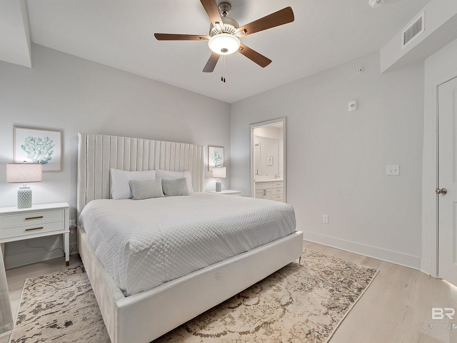 Master bedroom with upholstered headboard and coastal decor