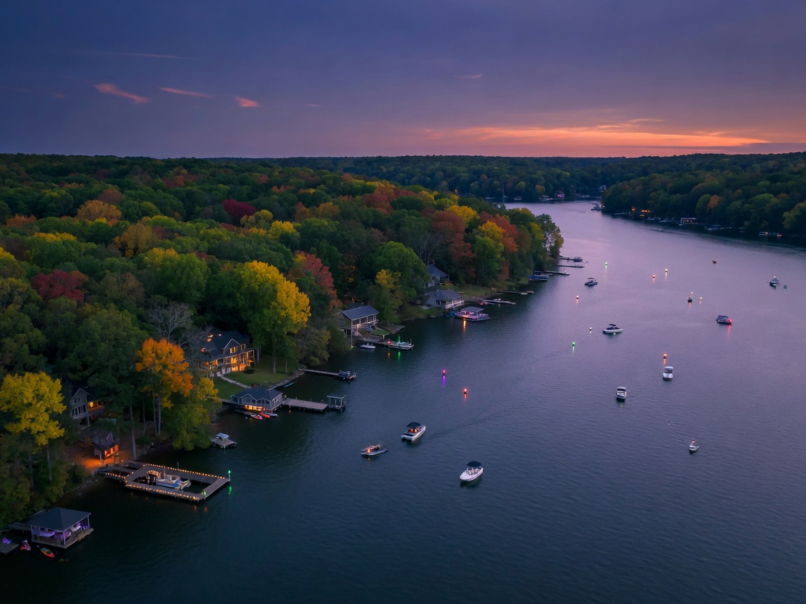 Overhead view of Lake Hartwell at twilight with boats on the water and dock lights dotting the forested shoreline