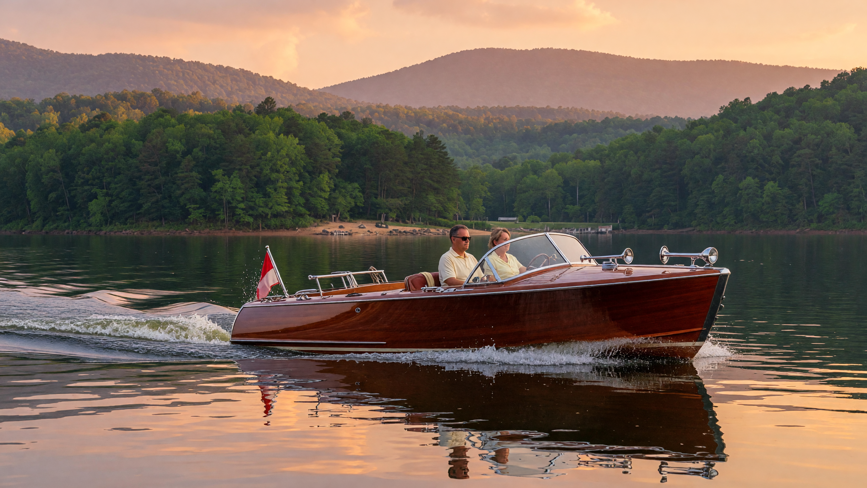 A classic wooden runabout boat with polished mahogany hull gliding across calm water on Lake Hartwell at golden hour, Appalachian foothills lining the background