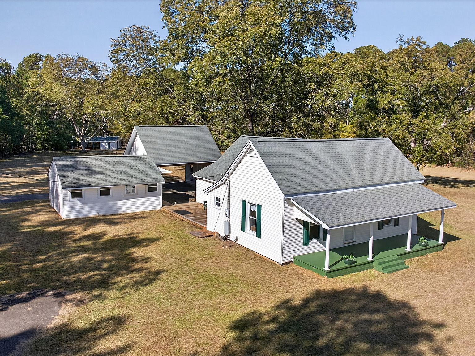 Low aerial view of the historic 1873 farmhouse with white siding and gray roof