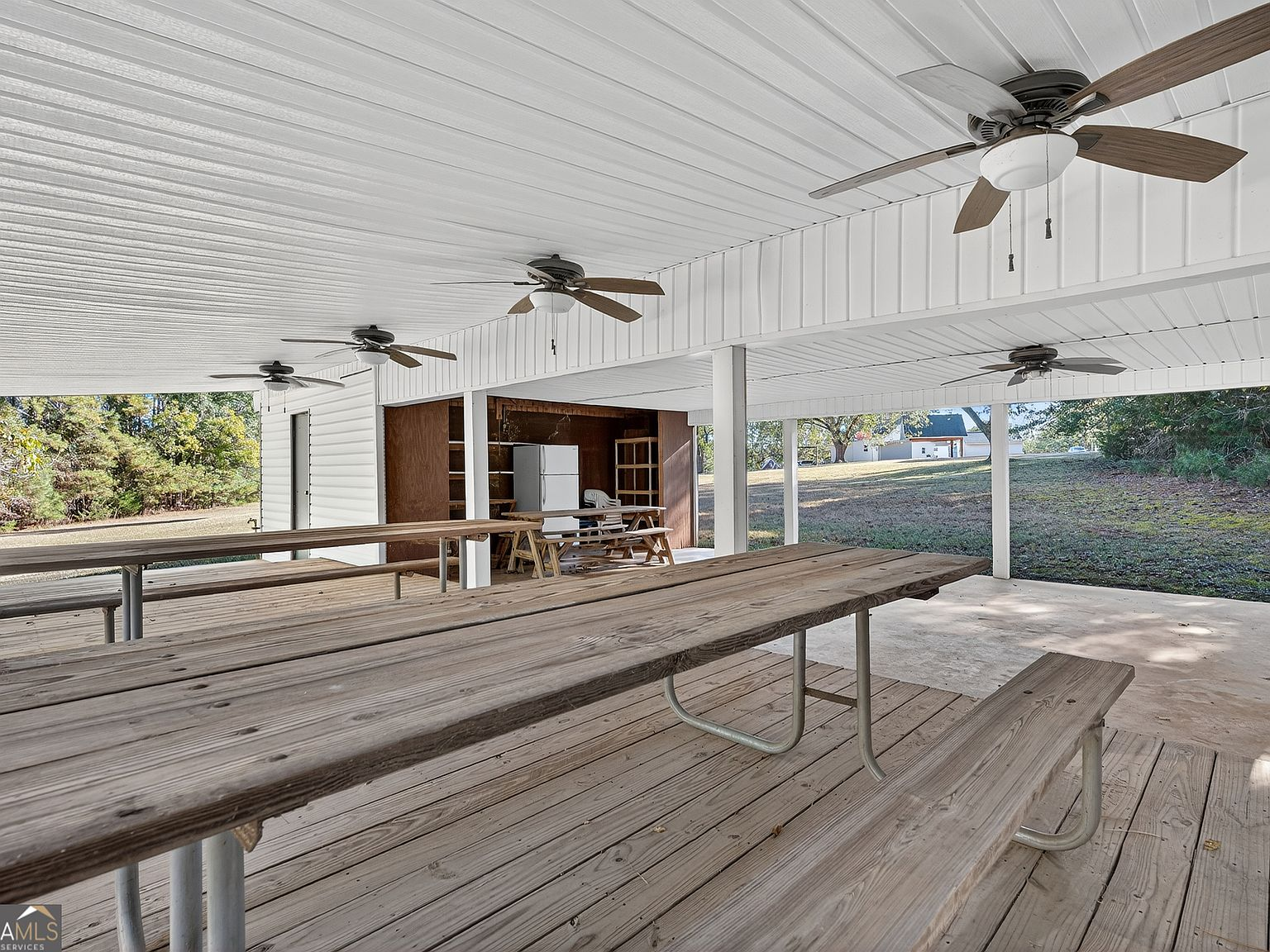 Large covered outdoor lakeside pavilion with dining tables and ceiling fans