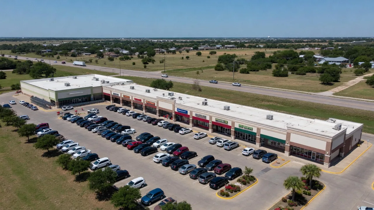 Aerial view of a grocery-anchored retail shopping center in a Texas town with ample parking and national brand storefronts
