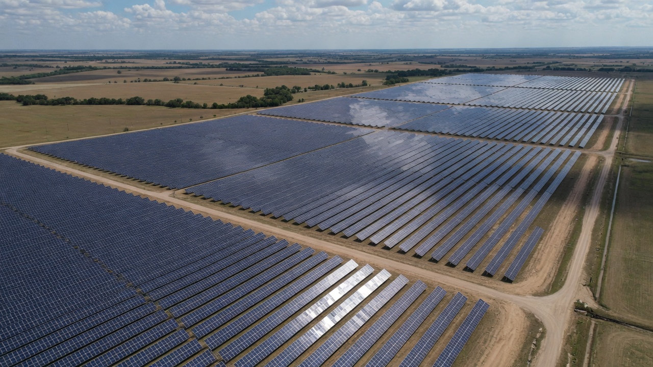 Aerial view of a large solar farm installation with rows of bifacial panels across rural Texas land