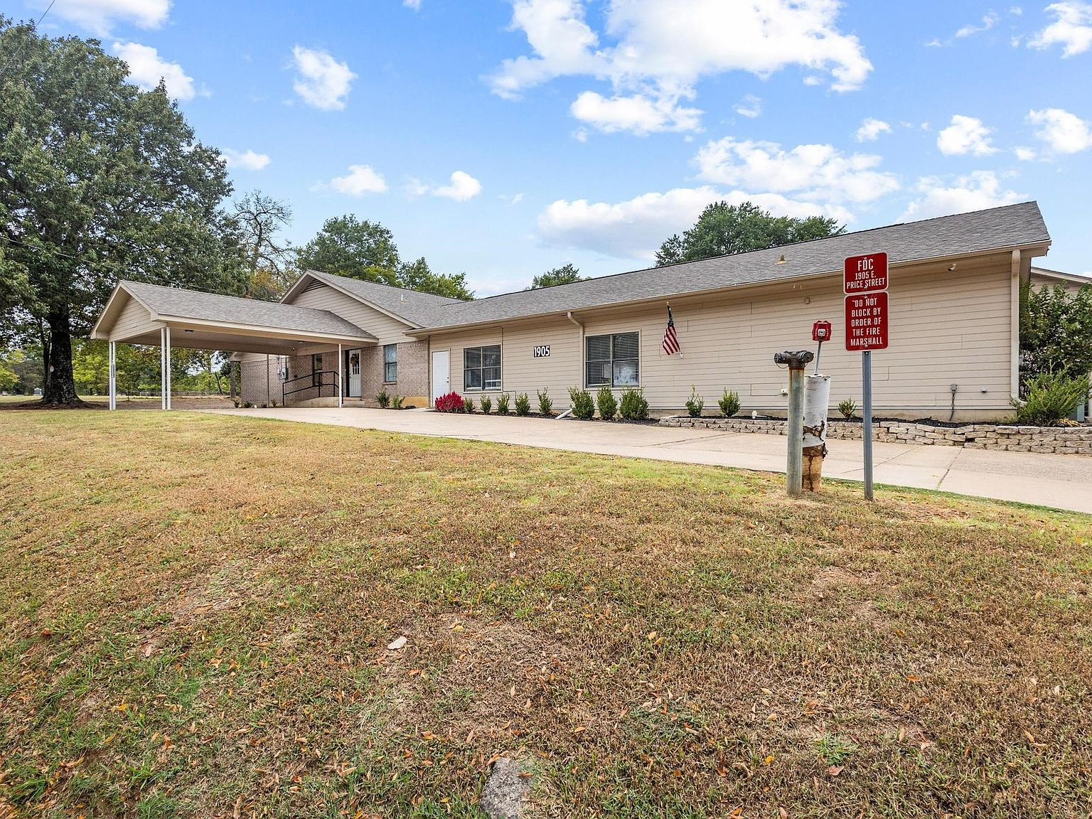 Wide exterior view showing dual road frontage and covered drive-through portico