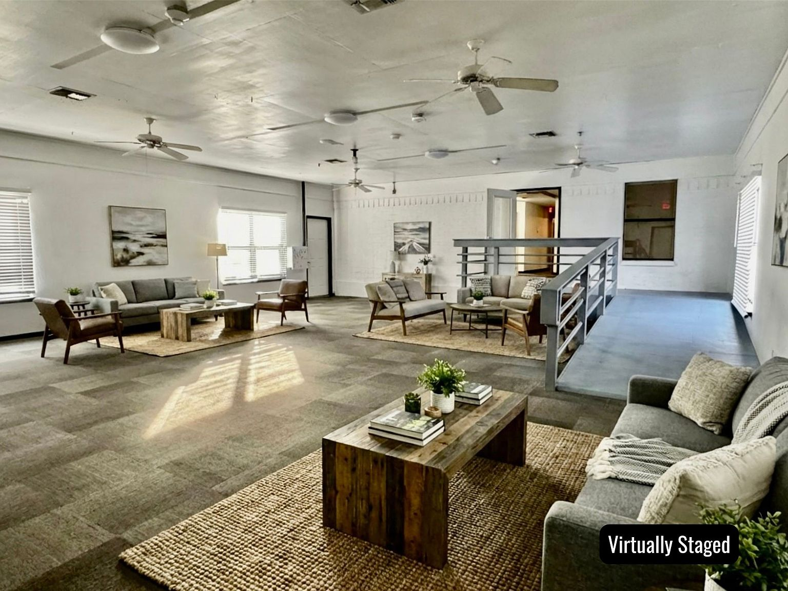 Large open-concept flex space with multiple seating areas and exposed ceiling structure