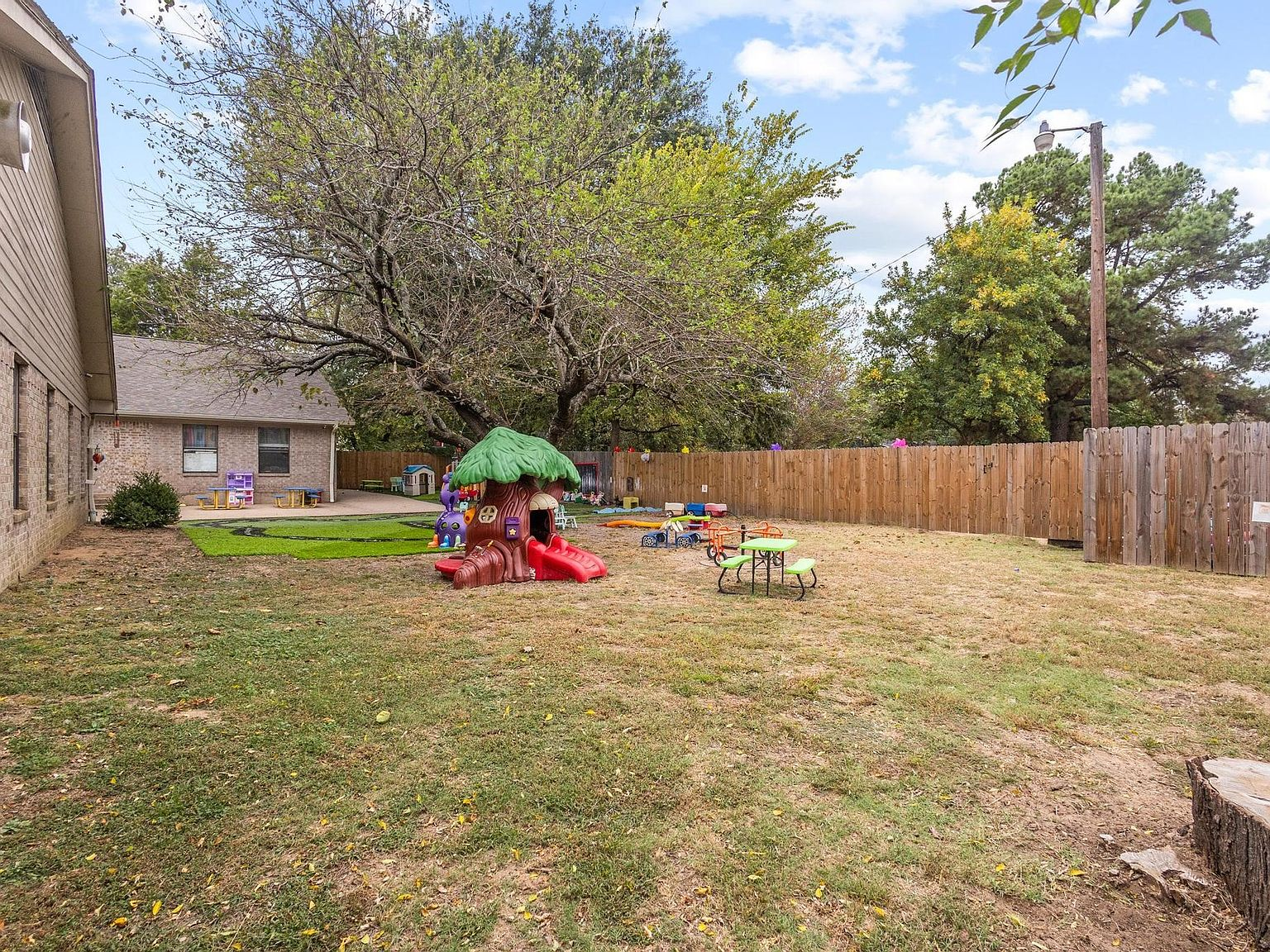 Large fenced backyard area with mature trees