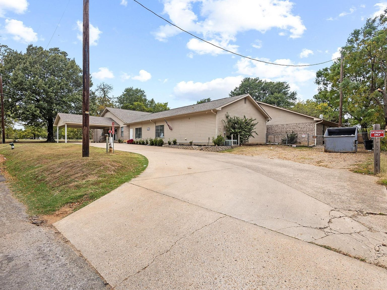 Side exterior view with long concrete driveway and covered entrance