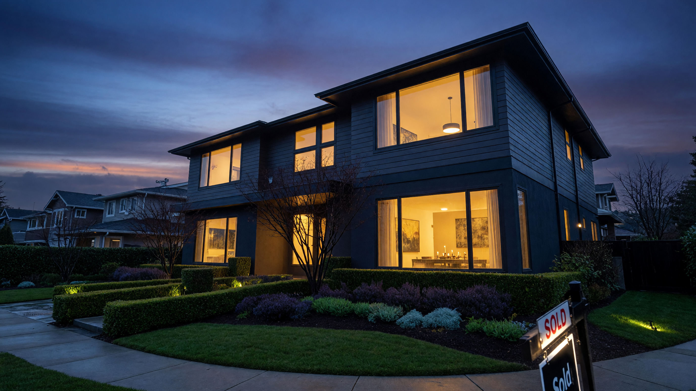 Modern home at dusk with warm interior light